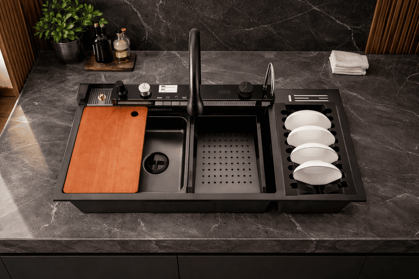 Modern kitchen sink with cutting board, plates, and bottles on a dark countertop.