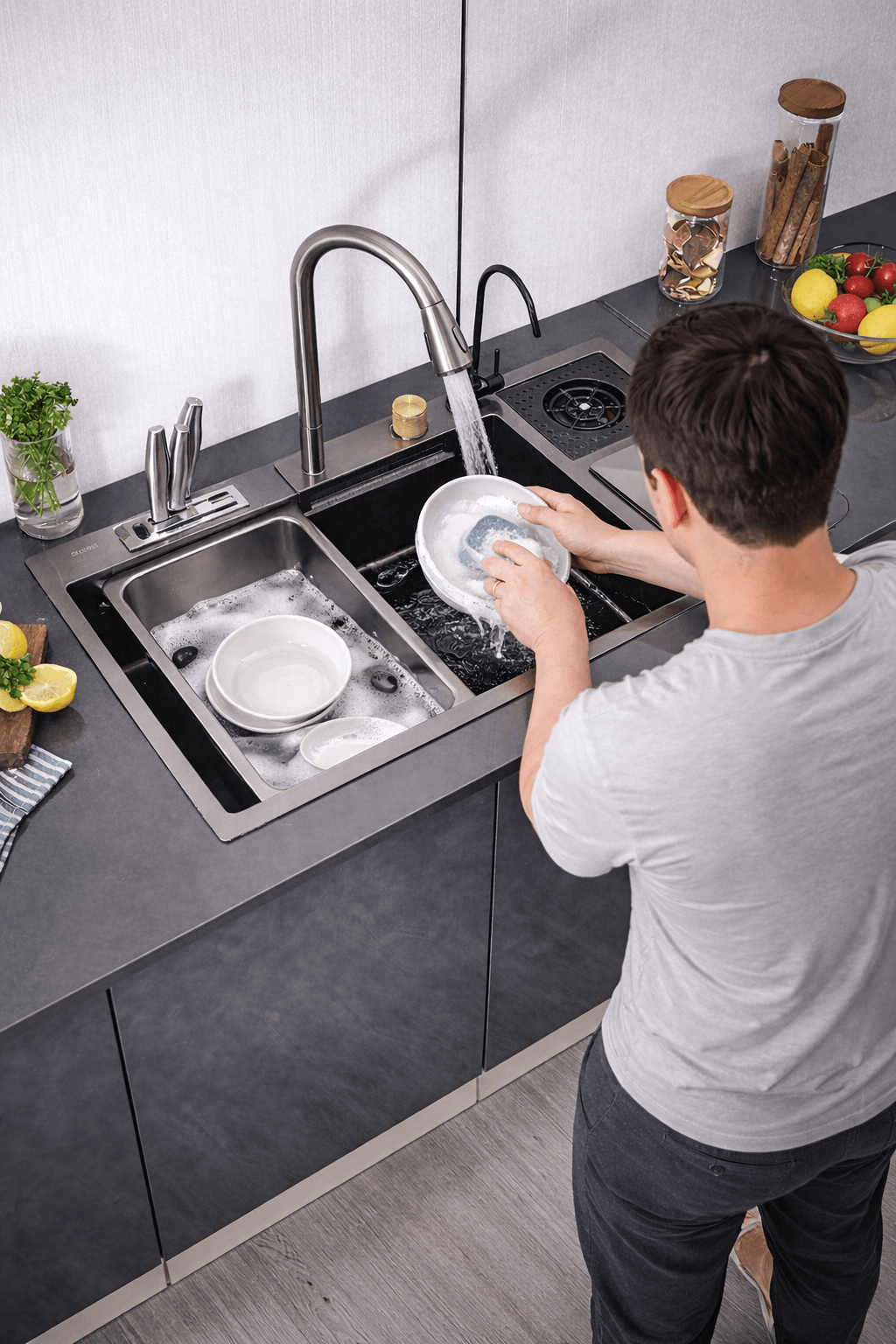 Person washing dishes in a modern kitchen with a sink and countertop.