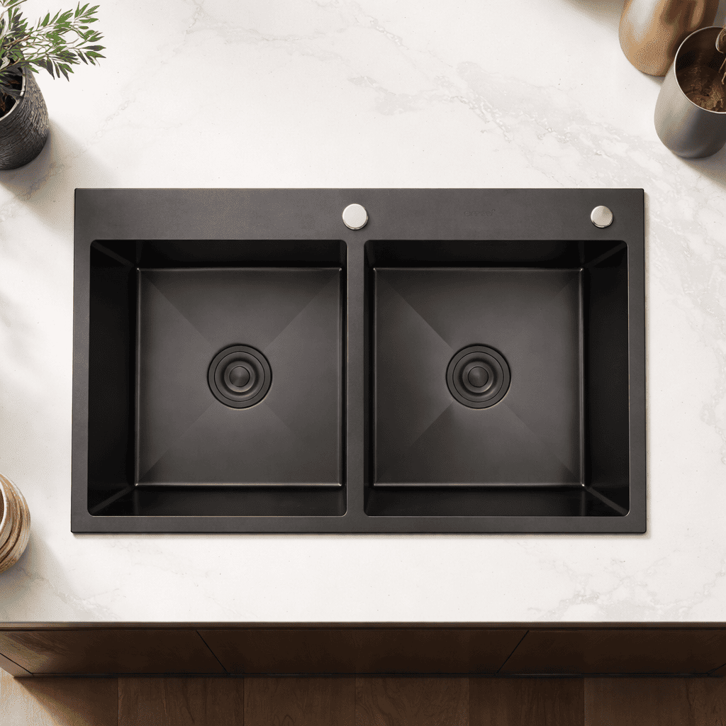 Black double-basin kitchen sink on a white countertop with decorative items.